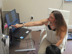 Chantea Goetz, PhD, MS, CES, Performance Psychologist, pointing at a computer screen during a biofeedback session in her Colts Neck, NJ office.